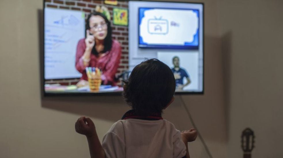 A preschool child Fabio Armendariz takes a class on television at his house, in Monterrey, state of Nuevo Leon, Mexico, on August 24, 2020. - Some 30 million Mexican students began a new school year on Monday with classes broadcast on television due to the new coronavirus pandemic. (Photo by Julio Cesar AGUILAR / AFP)  escuela primaria clases por zoom escuela clases on line  clases internet primaria alumno computadora  educacion a distancia  chicos laptop