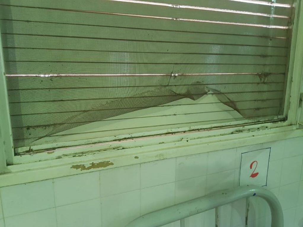 En tiempos de lucha contra el dengue, la tela mosquitera de una sala del hospital está en mal estado.