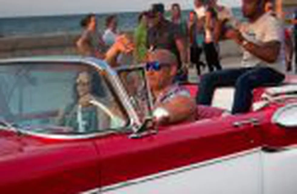 Actor Vin Diesel drives a vintage American car next to actress Michelle Rodriguez and another unidentified person in the back seat, after a session of filming of the latest installment of the 