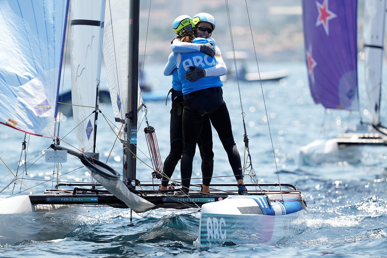 Eugenia Bosco y Mateo Majdalani de Argentina se abrazan después de cruzar la línea de meta en la carrera. (Foto AP/Carolyn Kaster)