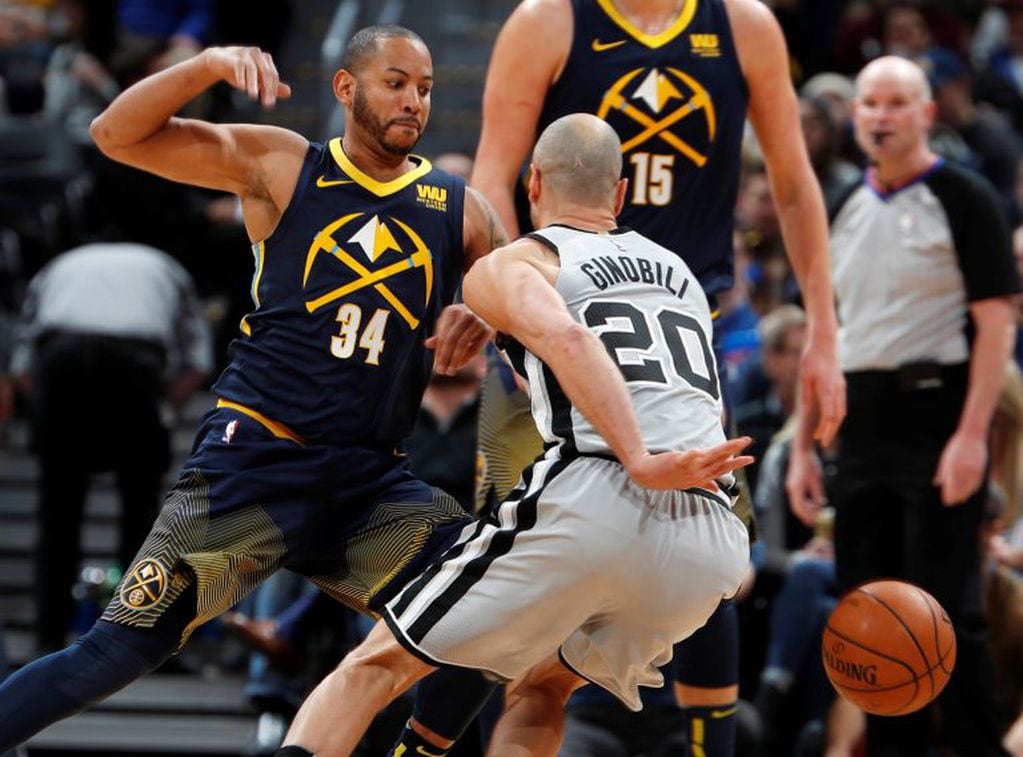 San Antonio Spurs guard Manu Ginobili, right, dribbles the ball behind his back as he gets around Denver Nuggets guard Devin Harris during the first half of an NBA basketball game Tuesday, Feb. 13, 2018, in Denver. (AP Photo/David Zalubowski)
