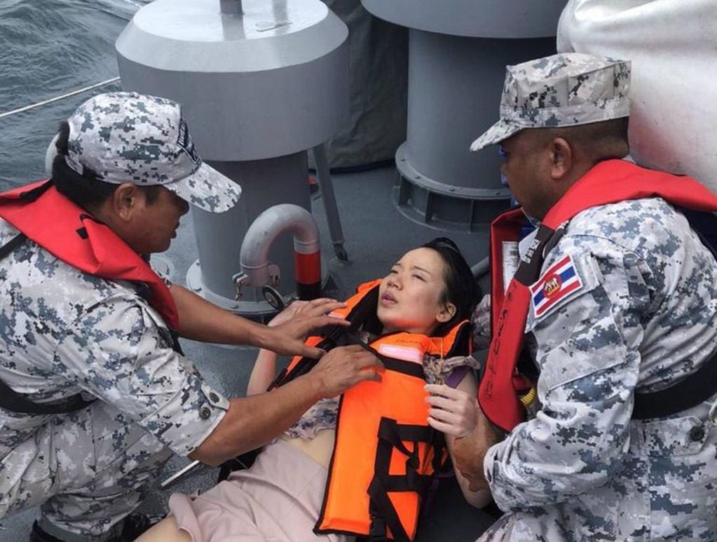 Efectivos de la Marina ayudan a una de las turistas rescatadas.