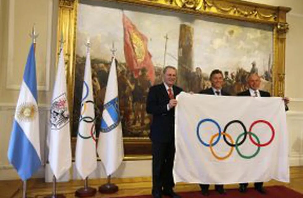 Jacqes Rogge (L), president of the International Olympic Commitee (IOC), Gerardo Werthein (R), president of the Argentine Olympic Committee, and Buenos Aires' Mayor Mauricio Macri hold an Olympic flag after a ceremony naming Rogge an 