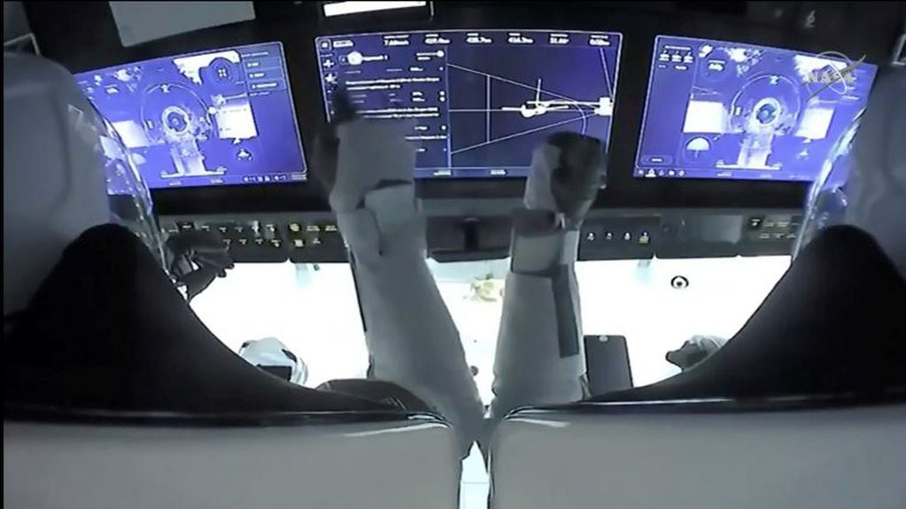 Los astronautas Mike Hopkins (a la izquierda) y Victor Glover, monitoreando los controles de la nave Crew Dragon durante su aproximación a la Estación Espacial.