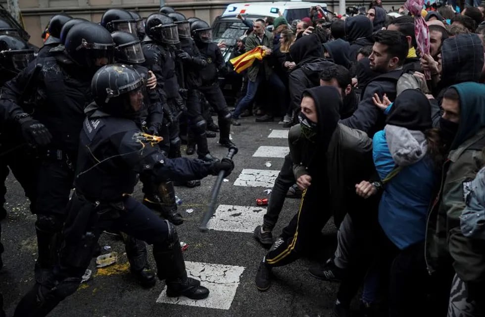 Catalan Mossos d'Esquadra regional police officers clash with pro-independence supporters trying to reach the Spanish government office in Barcelona, Spain, Sunday, March 25, 2018. Grassroots groups both for and against Catalan secession called for protests Sunday in Barcelona after Carles Puigdemont, the fugitive ex-leader of Catalonia and ardent separatist, was arrested Sunday by German police on an international warrant. (AP Photo/Felipe Dana)