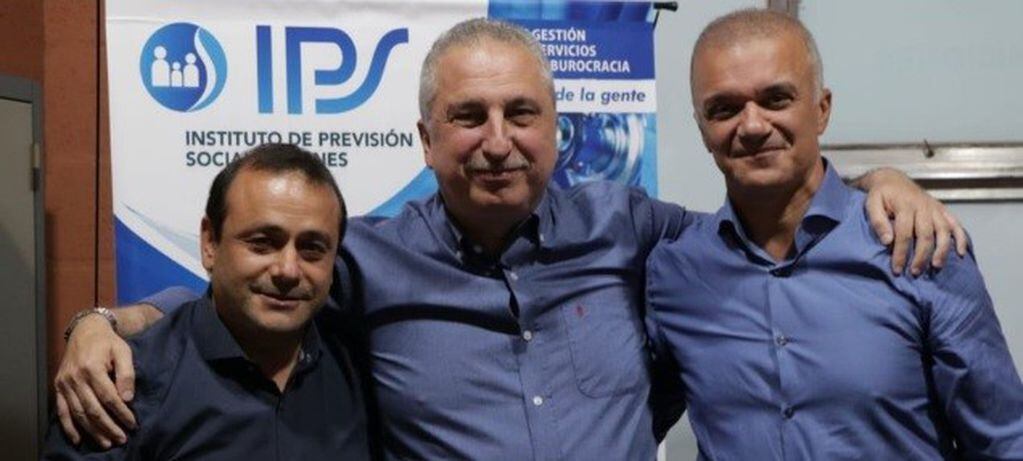El actual gobernador Hugo Passalacqua, en el medio, abraza a la fórmula electa, Oscar Herrera Ahuad a su drecha y Carlos Arce a su izquierda. (MisionesOnline)