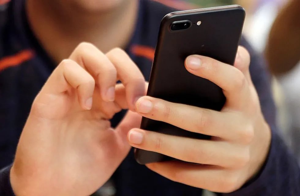 FILE - In this Sept. 16, 2017, file photo, a person uses a smart phone in Chicago. For many of us, a smartphone addiction is not so much a debilitating disease but a constant, nagging inconvenience we can’t seem to shake. But it’s not all our fault. From the constant notifications to the color schemes to the \