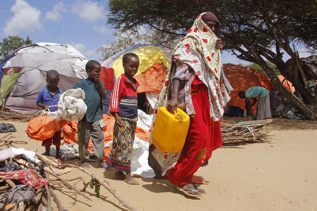 Una mujer camina con sus hijos en un campamento para desplazados después de que huyeran de una sequía, el martes 26 de septiembre de 2023, en las afueras de Mogadiscio, Somalia.