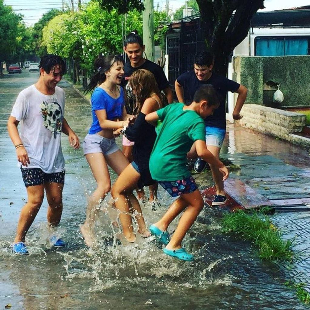 Las fotos de los adolescentes cordobeses jugando bajo la lluvia fueron tomadas por Juan Pablo Rodríguez, en barrio Los Naranjos.