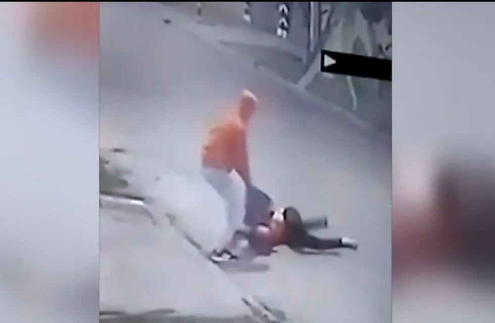 Una de las imágenes captadas por las cámaras de seguridad, donde el delincuente arrastra a su víctima. (Captura de video).