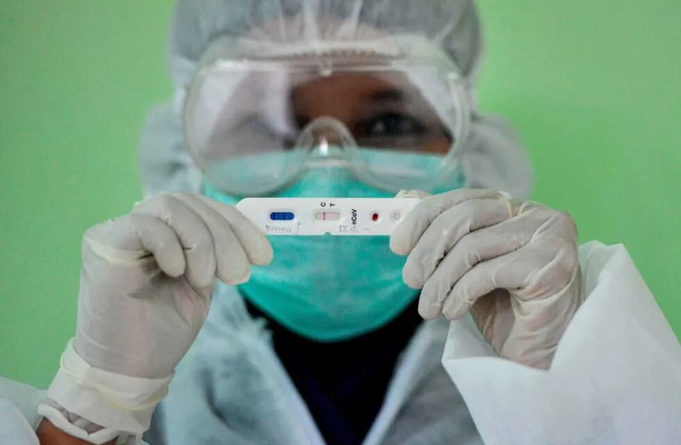 TOPSHOT - An Indonesian medical worker clad in protective gear poses with a blood test sample during mass testing for the COVID-19 coronavirus at a community health centre in Banda Aceh on April 20, 2020. (Photo by CHAIDEER MAHYUDDIN / AFP)