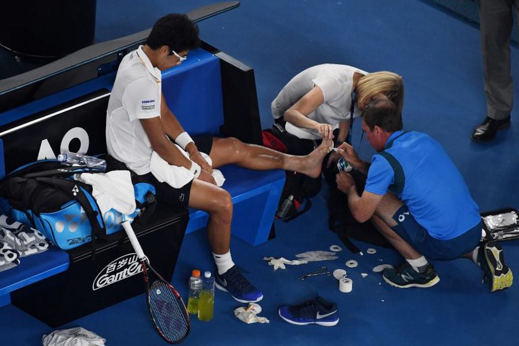 El tenista surcoreano Hyeon Chung, trata de aliviar su dolor el 26/01/2018 en Melbourne, Australia, durante el partido que lo enfrentó con el suizo Roger Federer durante el Abierto de tenis del país. Foto: Dean Lewins/AAP/dpa +++ dpa-fotografia +++