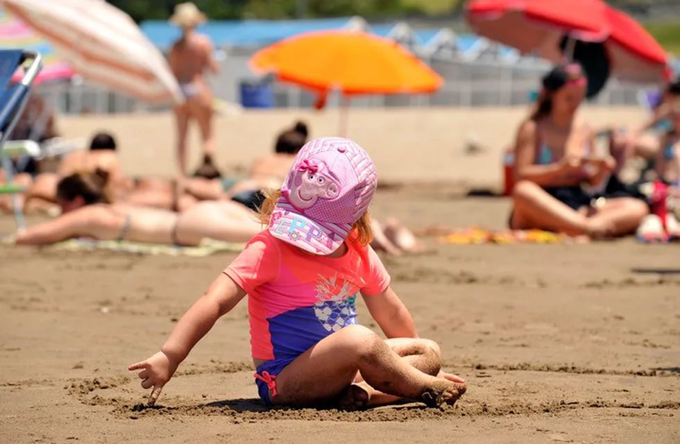 Niños jugando en la playa con remeras UV. (Foto: Maxi Failla/Clarín)