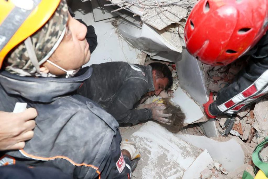 Un rescatista calma a Ayda Gezgin, de tres años, atrapada entre los escombros tras un sismo en Turquía (AFAD / AFP)