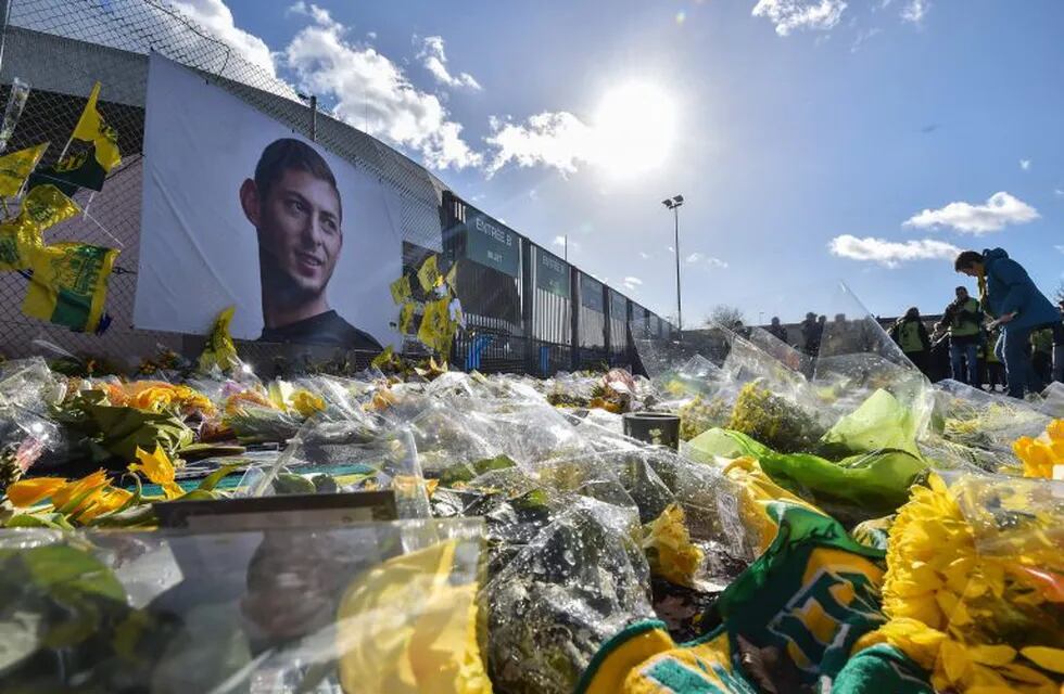 TOPSHOT - FC Nantes supporters gather in front of a portrait of late Argentinian forward Emiliano Sala prior to the French L1 football match between FC Nantes and Nimes Olympique at the La Beaujoire stadium in Nantes, western France on February 10, 2019. - FC Nantes football club announced on February 8, 2019 that it will freeze the #9 jersey as a tribute to Cardiff City and former Nantes footballer Emiliano Sala who died in a plane crash in the English Channel on January 21, 2019. (Photo by LOIC VENANCE / AFP) francia nantes  muerte futbolista del nantes cuando volaba sobre el canal de la mancha homenajes ofrendas