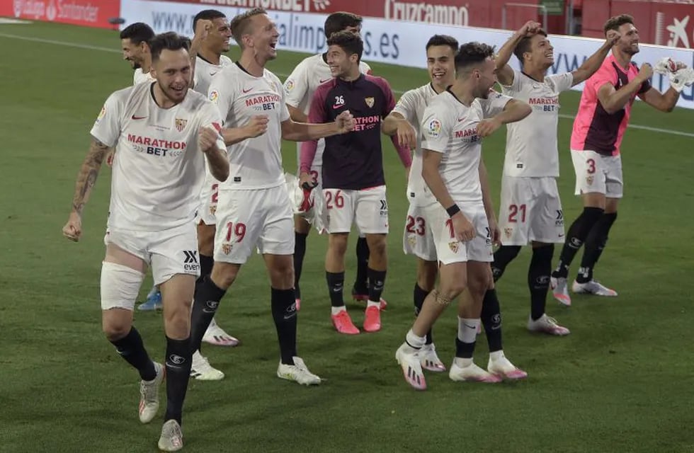 Sevilla's players celebrate at the end of the Spanish League football match between Sevilla FC and Real Betis at the Ramon Sanchez Pizjuan stadium in Seville on June 11, 2020. (Photo by CRISTINA QUICLER / AFP)