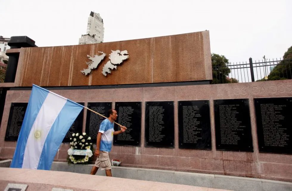 A man carries Argentina's national flag in front of the wall with names of those who died in the 1982 war between Britain and Argentina in the Falkland Islands, known to Argentines as 'Malvinas', at the memorial dedicated to them as today marks the 35th anniversary of the war, in Buenos Aires, Argentina, April 2, 2017. REUTERS/Martin Acosta buenos aires  35 años aniversario de la guerra de islas malvinas monumento malvinas homenaje a los soldados caidos