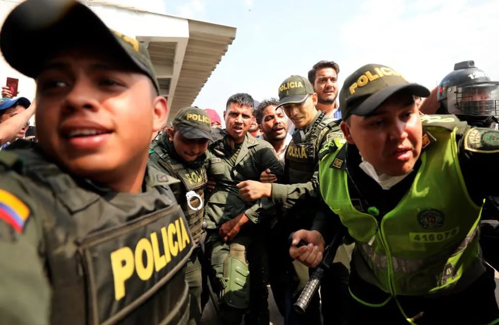 Colombian police escort a Venezuelan soldier who surrendered at the Simon Bolivar international bridge, where Venezuelans tried to deliver humanitarian aid despite objections from President Nicolas Maduro, in Cucuta, Colombia, Saturday, Feb. 23, 2019. Opposition leader Juan Guaido says the military is key to restoring democracy in Venezuela, although masses of soldiers appear to remain loyal to Maduro.  (AP Photo/Fernando Vergara)