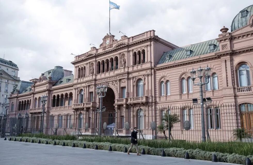 A pedestrian wearing a protective mask walks in front of the Casa Rosada in Buenos Aires, Argentina, on Tuesday, May 5, 2020. Argentina's nationwide lockdown, currently set to end on May 10, will probably be extended. Smaller cities may return to normal activities sooner if they meet five requirements, such as restricting movement to just half of their population at any given time. Photographer: Erica Canepa/Bloomberg