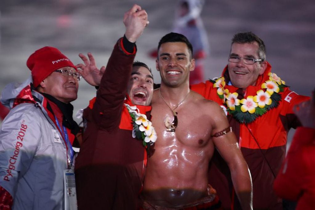 Tonga's flagbearer Pita Taufatofua (C-R) takes a selfie as his country's delegation parade during the opening ceremony of the Pyeongchang 2018 Winter Olympic Games at the Pyeongchang Stadium on February 9, 2018. / AFP PHOTO / POOL AND AFP PHOTO / -