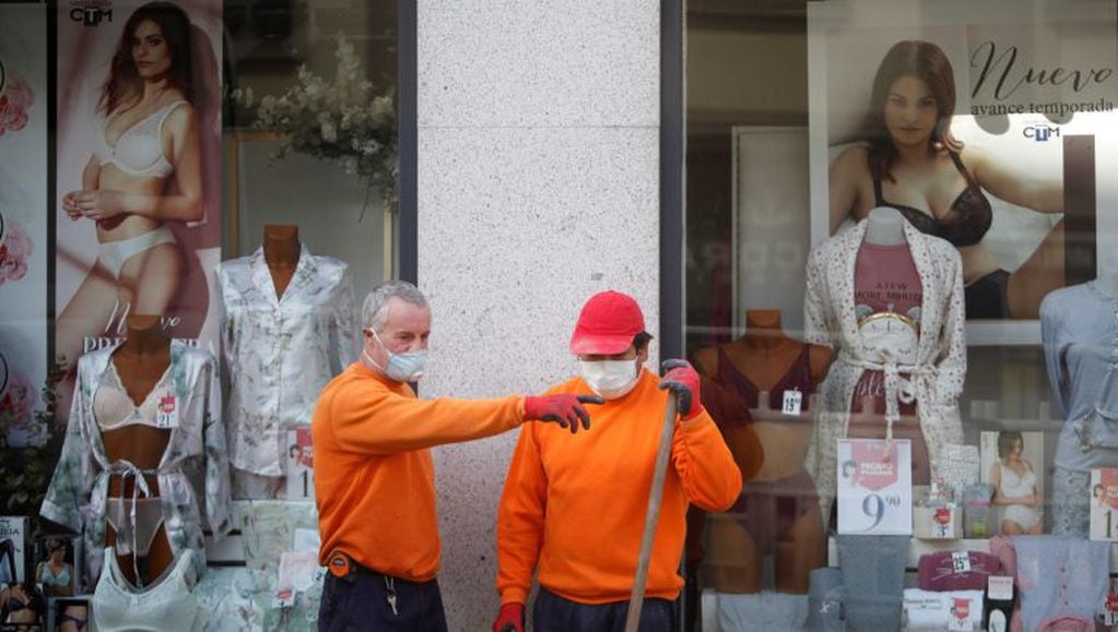 Dos obreros, protegidos con mascarilla, trabajan en una obra en A. Coruña, este lunes (EFE)