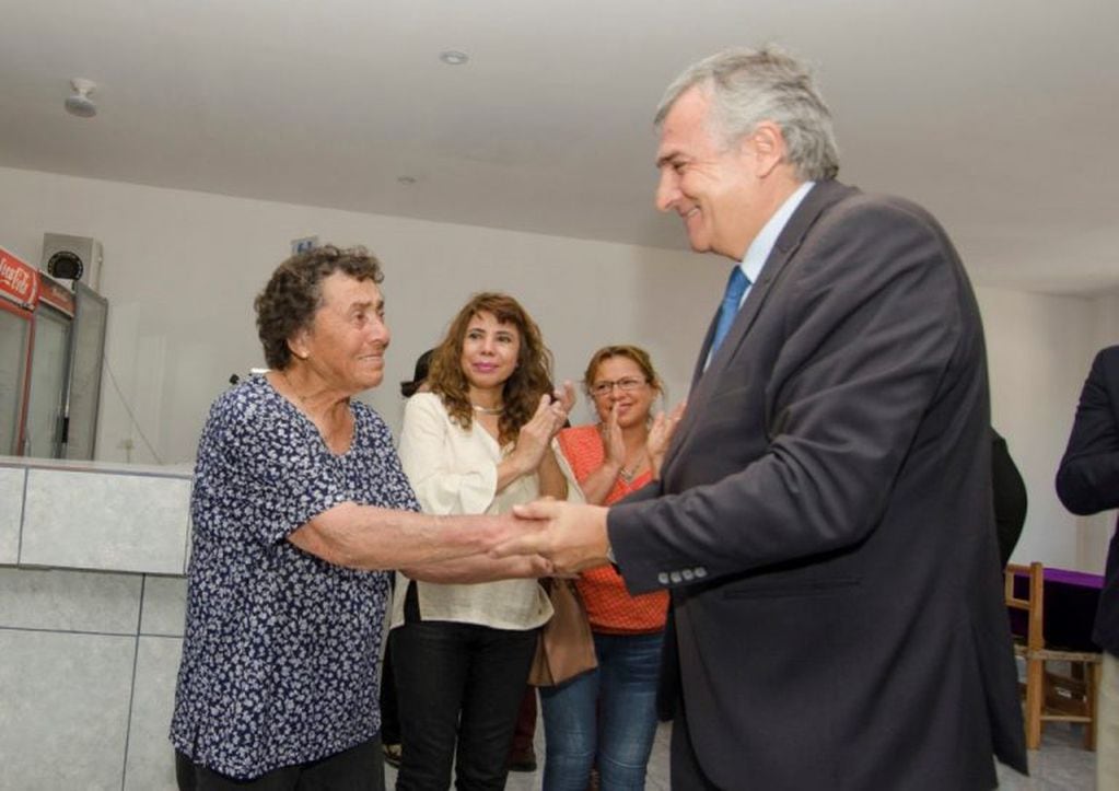 La señora Santa Evarista Condorí, vecina de Volcán y propietaria junto a su familia del restaurant que fue reconstruido totalmente, recibe el saludo del gobernador Morales.