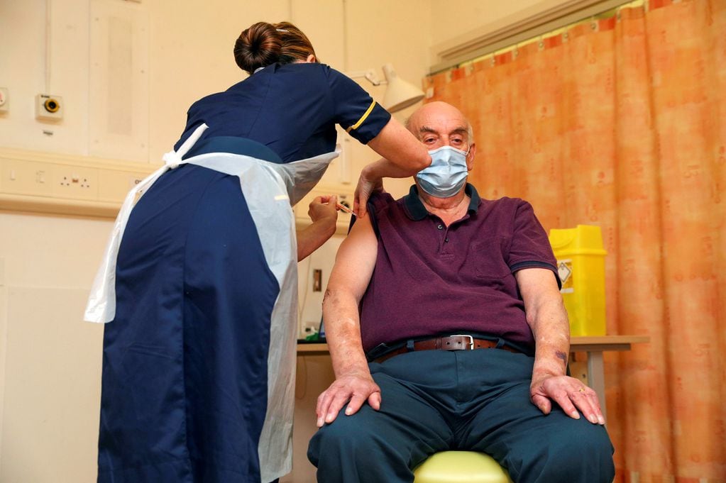 Brian Pinker, de 82 años, recibe la vacuna contra el COVID-19 en el Hospital Churchill en Oxford, Inglaterra.