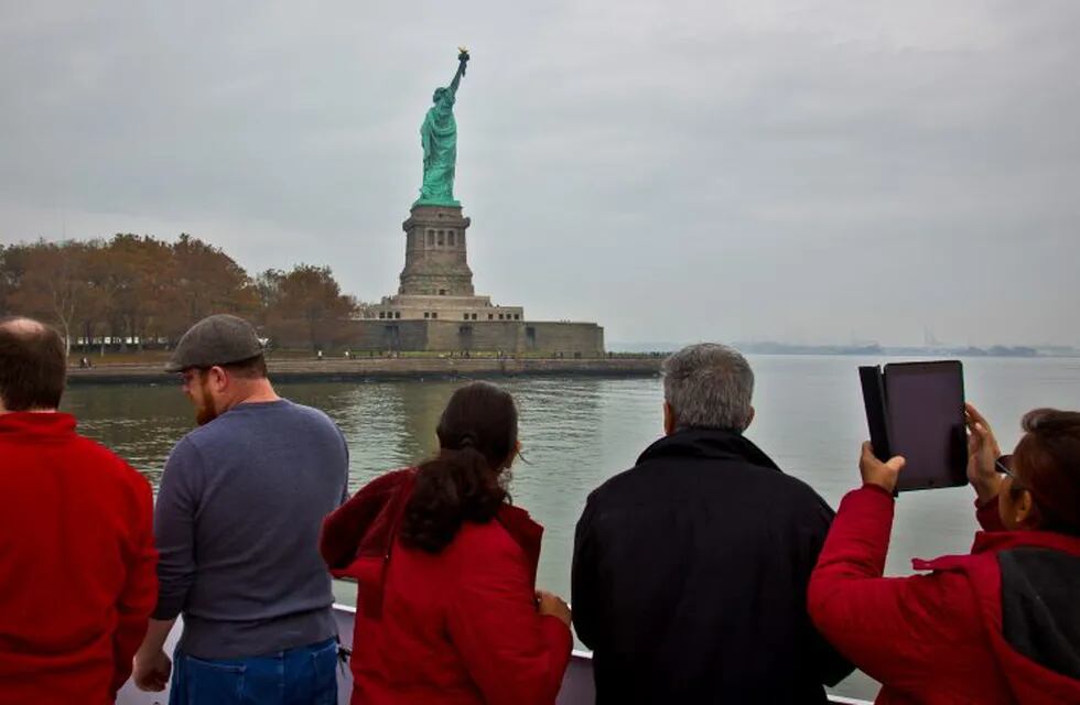 FILE - In this Nov. 5, 2015, file photo, visitors view the Statue of Liberty during a ferry ride to Liberty Island in New York. The U.S. Travel Association on Thursday, March 2, 2017, said there are 