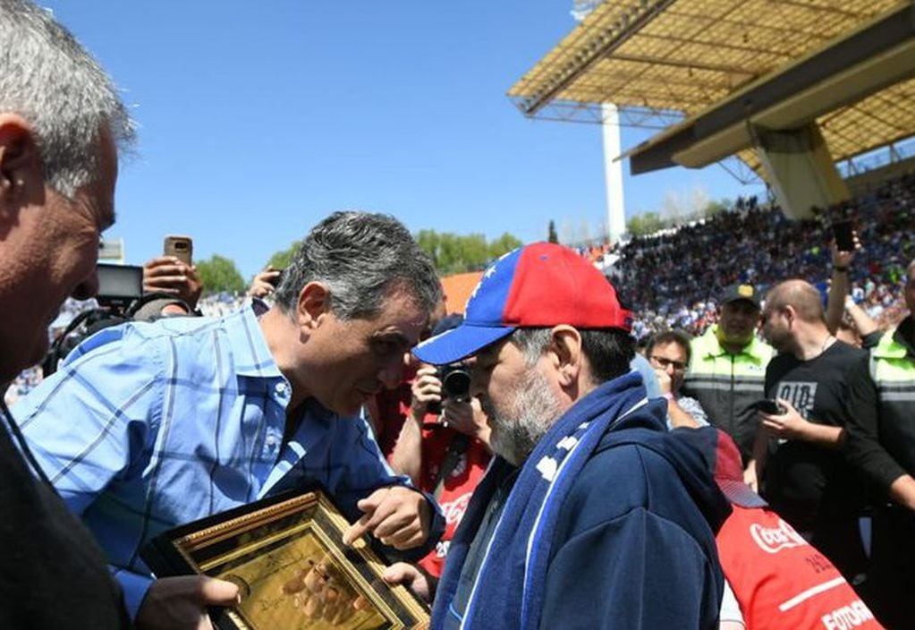El presidente de Godoy Cruz, José Mansur le entrega una plaqueta a Maradona.