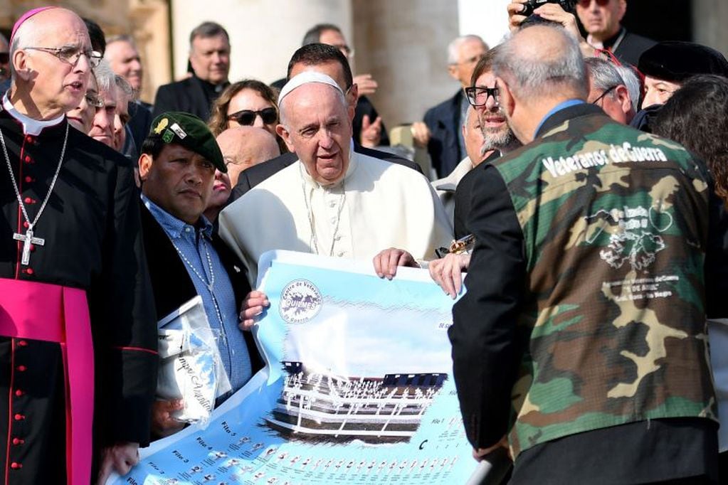 El Papa Francisco posa con un póster de un cementerio de las Malvinas (Malvinas) durante su audiencia general semanal en la plaza de San Pedro el 30 de octubre de 2019 en el Vaticano. Crédito: Alberto PIZZOLI / AFP.