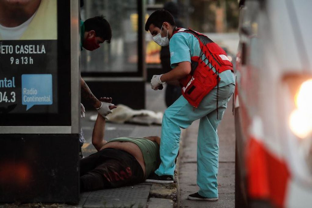 Personal médico asiste a un hombre tenido en una calle de la Villa 31 este jueves, en Buenos Aires (Argentina). (Foto: EFE/ Juan Ignacio Roncoroni)