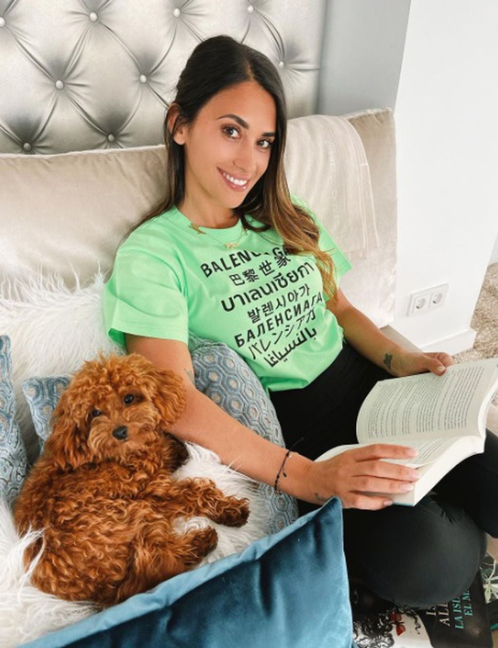 Antonela Roccuzzo leyendo un libro junto a su perro Abu. (@antonelaroccuzzo)