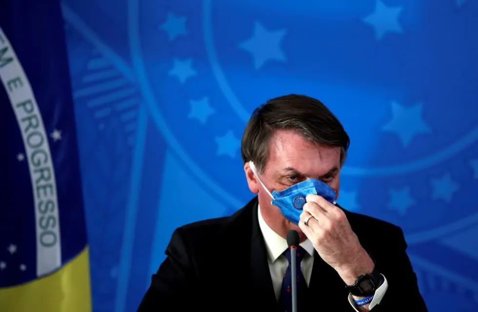 Brazil's President Jair Bolsonaro adjusts his protective face mask at a press statement during the coronavirus disease (COVID-19) outbreak in Brasilia, Brazil, March 20, 2020. Picture taken March 20, 2020. REUTERS/Ueslei Marcelino