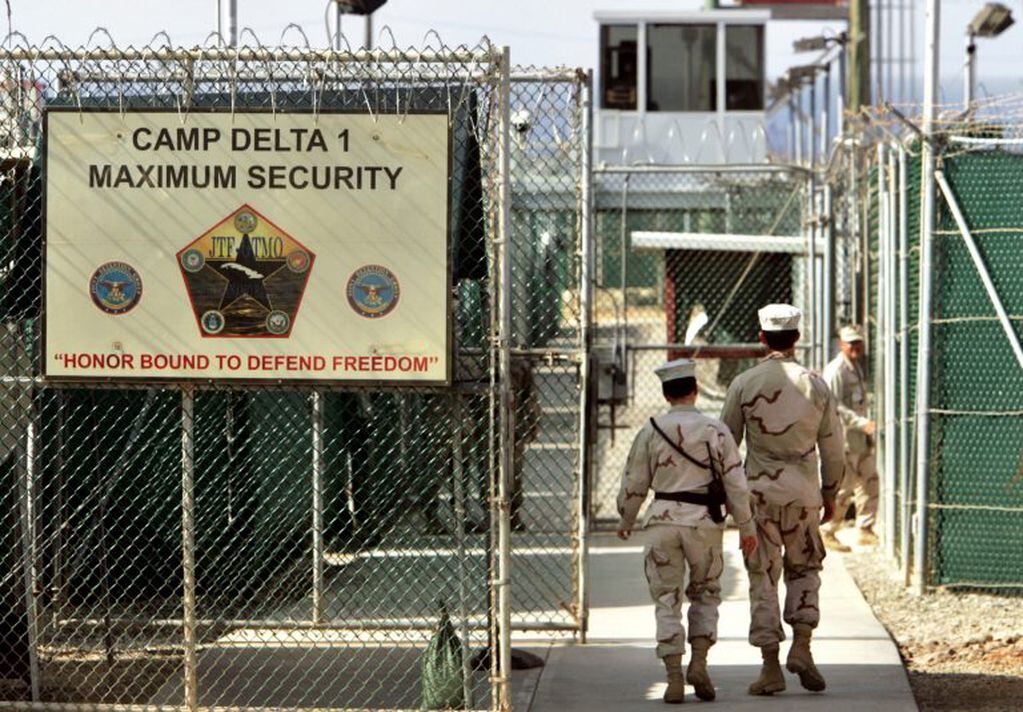 FILE - In this June 27, 2006 file photo, reviewed by a US Department of Defense official, US military guards walk within Camp Delta military-run prison, at the Guantanamo Bay US Naval Base, Cuba. A draft executive order shows President Donald Trump asking for a review of America’s methods for interrogation terror suspects and whether the U.S. should reopen CIA-run “black site” prisons outside the U.S.  (AP Photo/Brennan Linsley, file) cuba  base naval de guantanamo prision de la base naval de guantanamo