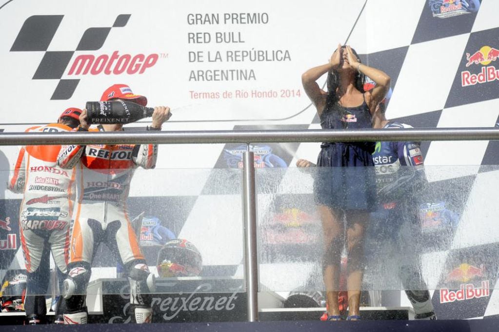El festejo de los pilotos en el podio; las promotoras, "blanco" del champagne.