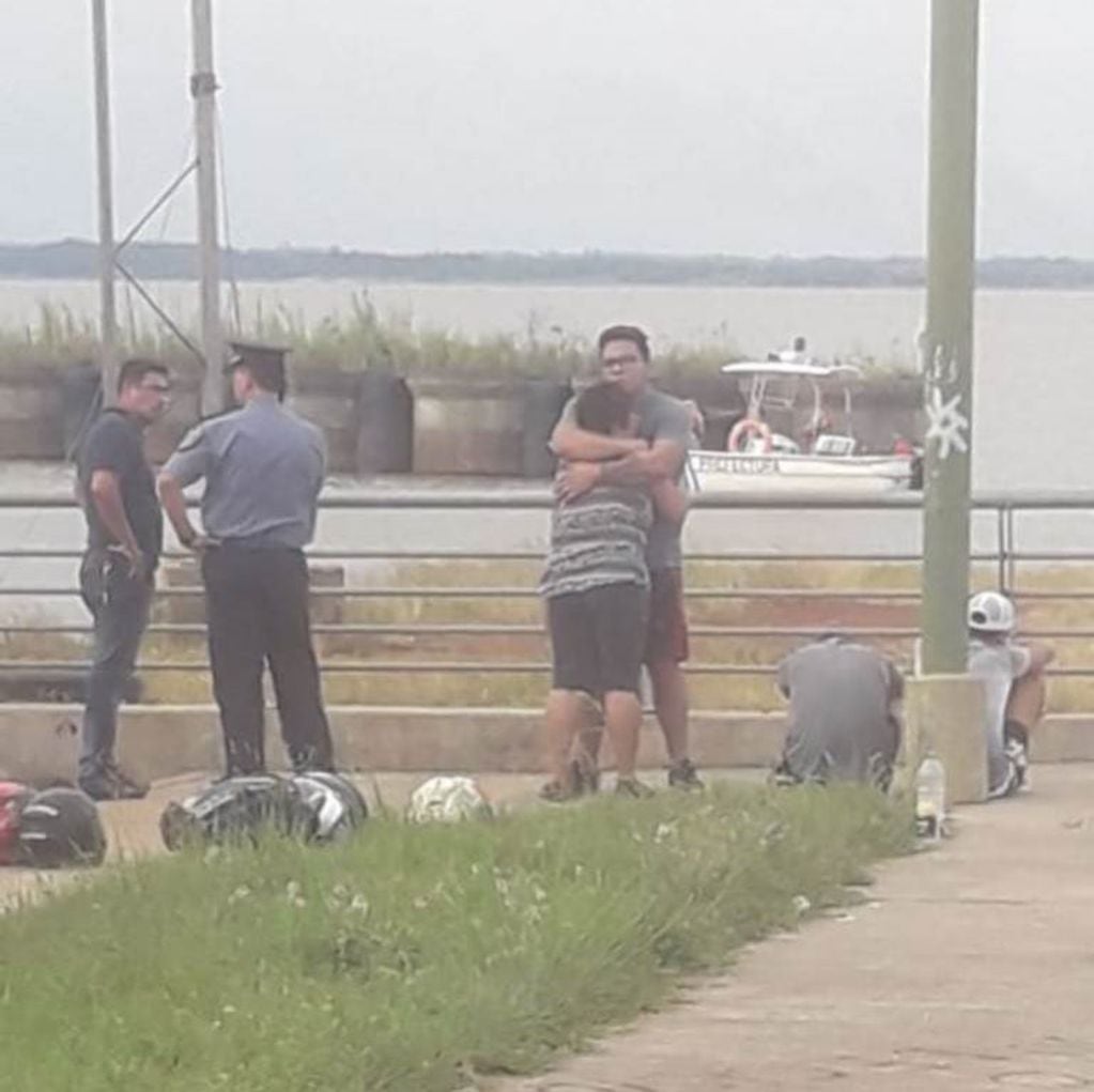 Los amigos de la víctima se abrazan ante la pérdida del joven en el agua. (Foto: Misiones Online).