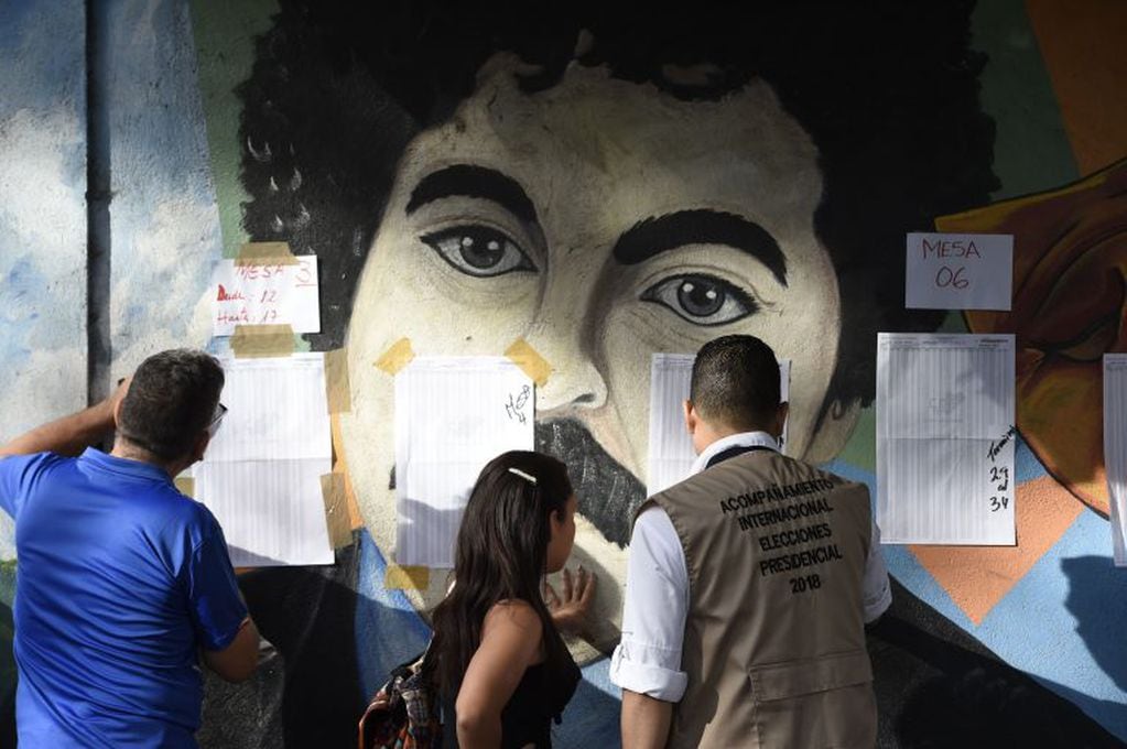 Venezolanos buscando sus nombres antes de votar en Caracas.