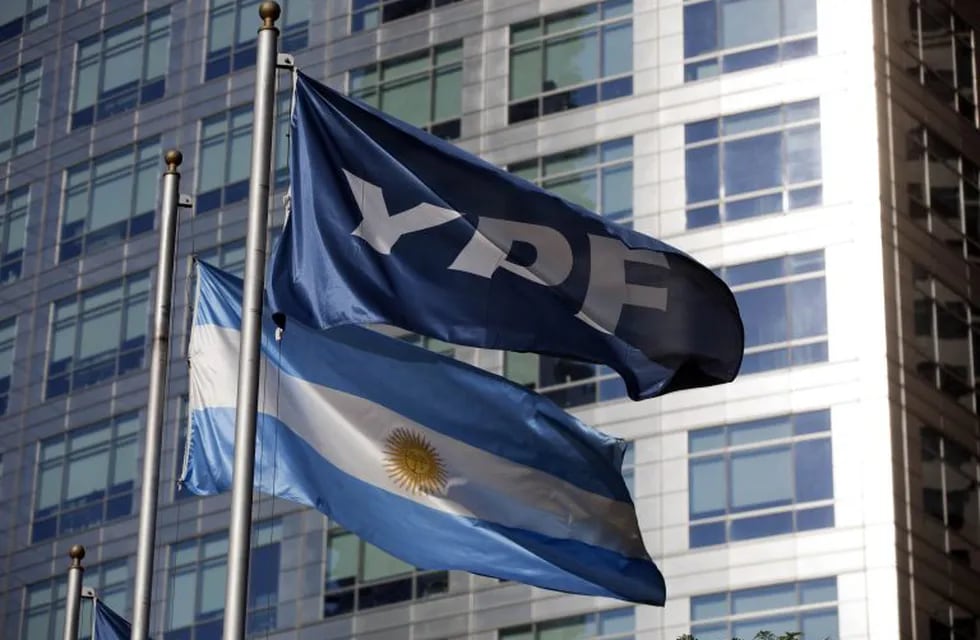 FILE - In this April 16, 2012 file photo, an Argentine national flag and a banner representing the YPF oil company flutter outside YPF headquarters in Buenos Aires, Argentina. Argentina's government said Monday, Nov 25, 2013, it has reached an agreement in principle to compensate Spain's Repsol for last year's 51 percent expropriation of the energy company. (AP Photo/Natacha Pisarenko, File) buenos aires  edificio sede de YPF frentes de edificios
