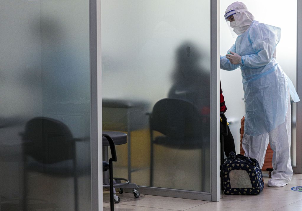 Una trabajadora sanitaria toma una muestra nasal para hacer una prueba de COVID a un pasajero llegado al aeropuerto internacional Arturo Merino Benítez en Santiago de Chile