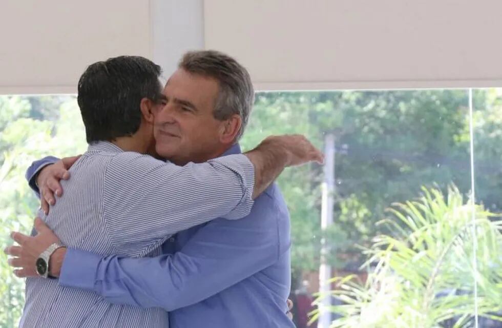 Capitanich abraza al diputado nacional Agustín Rossi al saludarlo durante visita a Chaco.
