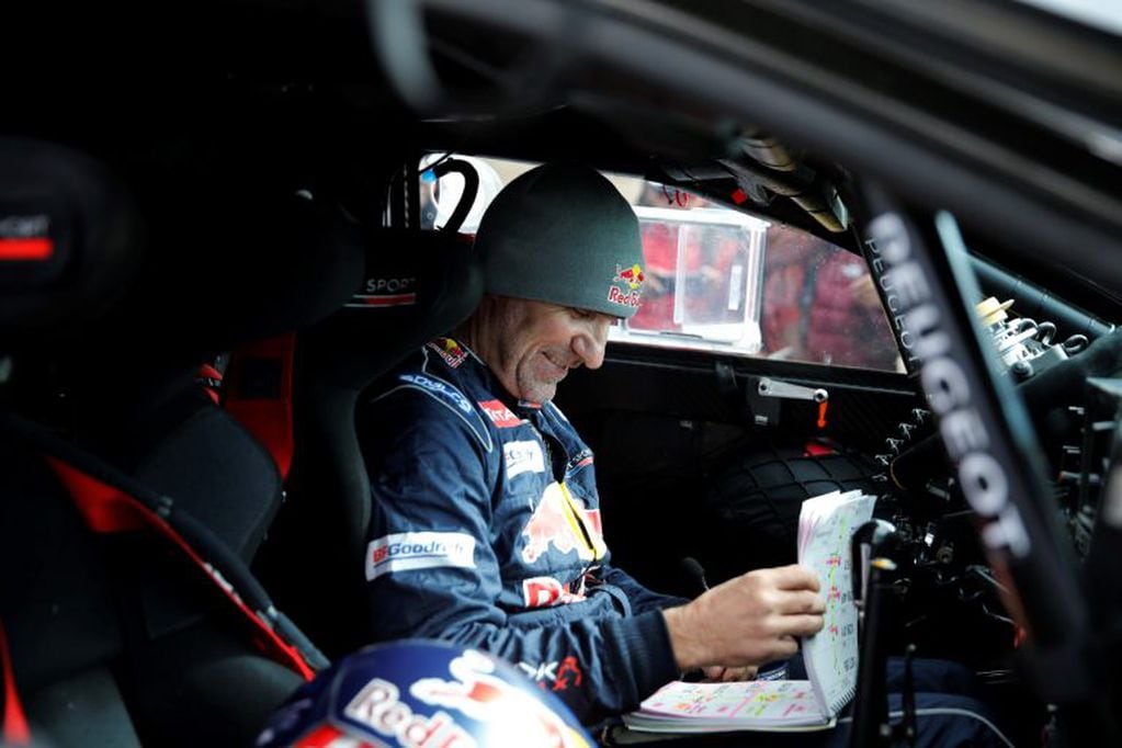 Driver Stephane Peterhansel, of France, sits in his Peugeot checking the road book during the 6th stage of the 2018 Dakar Rally between Arequipa, Peru, and La Paz, Bolivia, Thursday, Jan. 11, 2018. (Andres Stapff/Pool Photo via AP)
