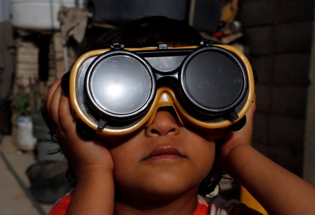 Un niño usa anteojos para observar un eclipse een Sanaa, Yemen (Foto: EFE/YAHYA ARHAB)