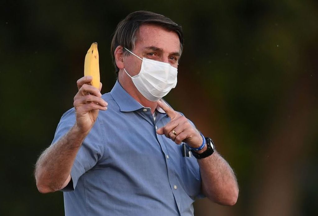 TOPSHOT - Brazilian President Jair Bolsonaro shows a banana to journalists as he walks towards supporters in the garden of the Alvorada Palace in Brasilia, on July 24, 2020. (Photo by EVARISTO SA / AFP)