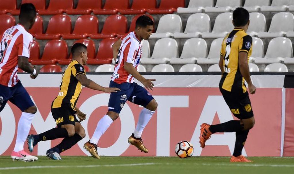 Colombia’s Atletico Junior player Teofilo Gutierrez ( C) vies for the ball with Paraguay's Guarani players Luis Cabral (L) and Robert Rojas during their Copa Libertadores football match at the  Defensores del Chaco stadium in Asuncion, Paraguay on February 22, 2018. / AFP PHOTO / NORBERTO DUARTE