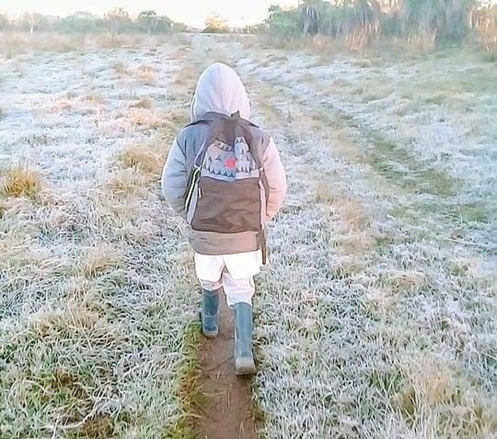 Un niño camina por la helada para llegar a la escuela.