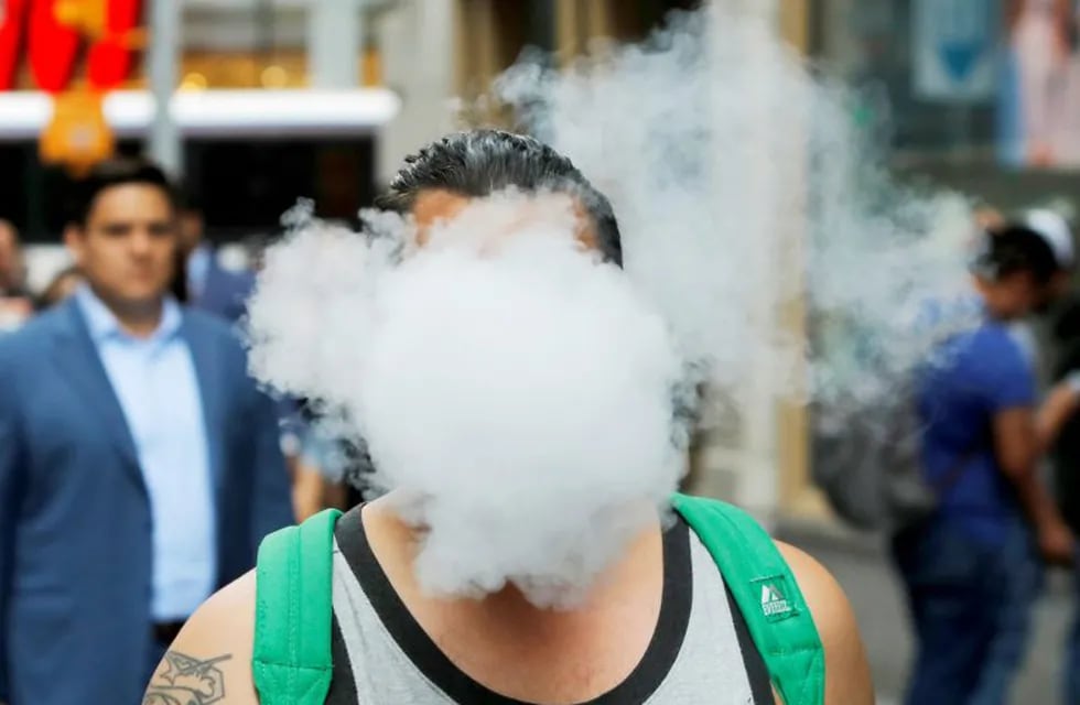 FILE PHOTO: A man uses a vape as he walks on Broadway in New York City, U.S., September 9, 2019. REUTERS/Andrew Kelly/File Photo