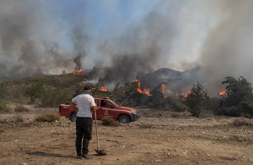 Un hombre observa las llamas que queman un monte en la localidad de Vati, en la isla de Rodas, en el sureste de Grecia, el 25 de julio de 2023. (AP Foto/Petros Giannakouris)