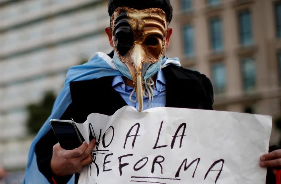 A man holds a poster with a message that reads in Spanish: \