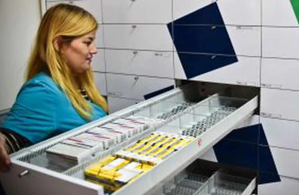 A worker of a pharmacy opens a half empty empty drewer in Caracas on May 30, 2016.rn The shortage of medicines in Venezuela exceeds 85%, revealed the president of the harmaceutical federation of Venezuela, Freddy Ceballos. / AFP PHOTO / RONALDO SCHEMIDT v