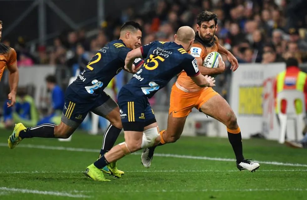 Jaguares' Matias Orlando (R) runs towards Highlanders' Patelesio Tomkinson (L) and Matt Faddes during the Super Rugby match between the Otago Highlanders and the Jaguares of Argentina in Dunedin on May 11, 2019. (Photo by Marty MELVILLE / AFP)
